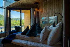 a bedroom with a couch with pillows and a window at Sorrisniva Arctic Wilderness Lodge in Alta
