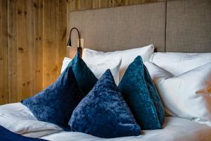 a bed with four blue pillows on it at Sorrisniva Arctic Wilderness Lodge in Alta