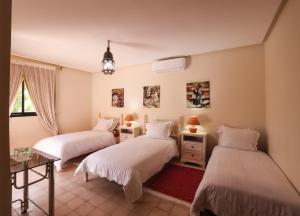 1 Schlafzimmer mit 2 Betten, einem Tisch und einem Tisch in der Unterkunft Tiguemine Sarah in Marrakesch