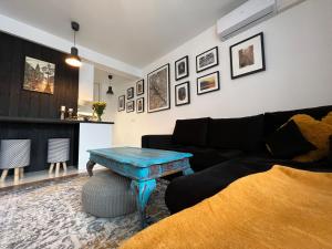 a living room with a couch and a table at FireSalamander Apartament z prywatną sauną - wyjątkowy i romantyczny, idealny na specjalne okazje in Ustrzyki Dolne