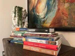 a stack of books on a table with a painting at FireSalamander Apartament z prywatną sauną - wyjątkowy i romantyczny, idealny na specjalne okazje in Ustrzyki Dolne