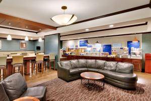 sala de estar con sofá de cuero y bar en Holiday Inn Express Hotel & Suites Butte, an IHG Hotel, en Butte