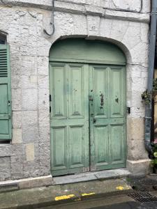 オンフルールにあるMoanaの石造りのアーチ型の緑の扉