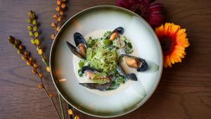 a plate of food with mussels and noodles on a table at Sorrisniva Arctic Wilderness Lodge in Alta