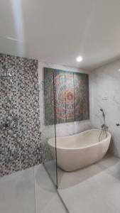 a bath tub in a bathroom with a painting on the wall at Kubu Garden Suites & Villas Nusa Dua in Nusa Dua