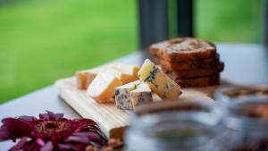 a cutting board with cheese and bread on a table at Sorrisniva Arctic Wilderness Lodge in Alta