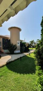 a house with a lawn in front of a building at Pousada Dom Quixote in São João da Barra