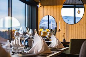 a table in a restaurant with wine glasses on it at Sorrisniva Arctic Wilderness Lodge in Alta