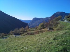 a grassy hill with a view of a valley at Lunheim in Geiranger in Geiranger
