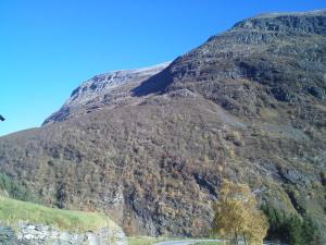 a mountain with a road in front of it at Lunheim in Geiranger in Geiranger