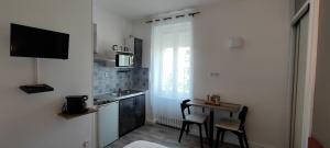 a small kitchen with a table and a sink at Guest Home location in Néris-les-Bains