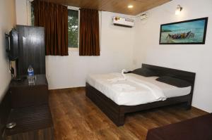 um quarto com uma cama e uma televisão em Coco homes by myroom em Candolim