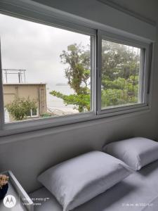 a window with two pillows sitting in front of it at FRANCIS HOTEL MAR in Caraguatatuba