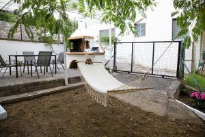 a hammock in a yard next to a house at Iria's Cosy House, BBQ, garden, indoor fireplace in Sparti