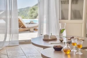 a table with wine glasses and a table with a view at Korypho Villas in Barbati