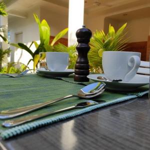 un tavolo di legno con scacchiera, tazze e torre degli scacchi di Konut by Thakuru a Guraidhoo