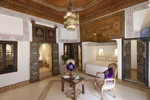 - une chambre avec un lit, une table et un lustre dans l'établissement Riad Palais Des Princesses & Spa, à Marrakech