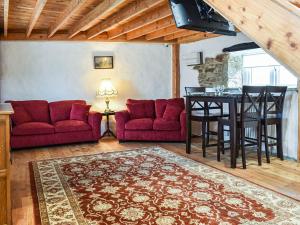 ein Wohnzimmer mit zwei roten Sofas und einem Tisch in der Unterkunft The Old Barn in Saint Day