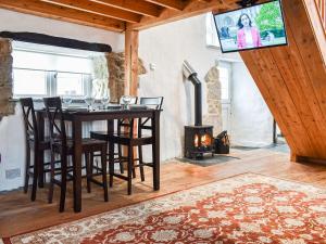 a dining room with a table and chairs and a fireplace at The Old Barn in Saint Day