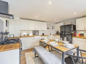 uma cozinha com armários brancos e uma mesa de madeira em No, 2 Ness Street em Berwick-Upon-Tweed