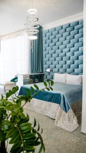 a blue bedroom with a bed and a blue wall at Boutique Spa Casino Hotel Lybid Plaza in Khmelnytskyi