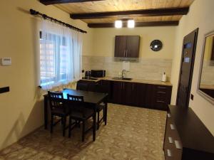 a kitchen with a table and chairs in a room at Apartamentai Pušyne in Druskininkai