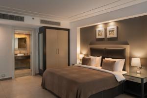 a bedroom with a large bed and a bathroom at Rhactus Hotel, New Alamein in El Alamein