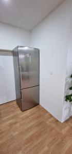 a stainless steel refrigerator in a room with a wooden floor at APARTMAN MURKO P-3 