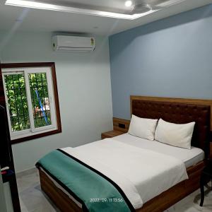 a bedroom with a white bed with a window at VIAN INN in Guwahati
