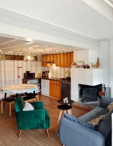 a living room with a couch and a table and a kitchen at Gîte cosy Lac de Payolle in Campan