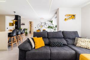 uma sala de estar com um sofá cinzento e uma cozinha em Apartamento inteligente con vistas a la Alhambra em Granada