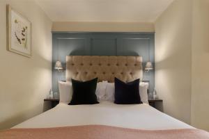 ストウ・オン・ザ・ウォルドにあるロイヤリスト ホテルのベッドルーム(白い大型ベッド、黒い枕付)