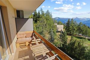 d'un balcon avec une chaise et une vue sur les montagnes. dans l'établissement Magnifique appartement avec vue sur les montagnes, à Crans-Montana