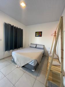a bedroom with a bed and a ladder in it at Mar de Gente Pousada in Praia de Moitas