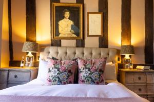 ストウ・オン・ザ・ウォルドにあるロイヤリスト ホテルのベッドルーム1室(壁に肖像画が飾られたベッド1台付)