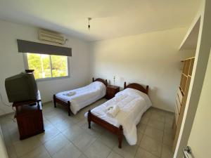 a bedroom with two beds and a tv in it at Departamento Temporario La Quebrada in La Rioja