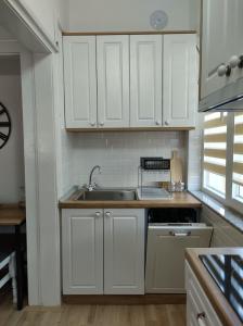 een keuken met witte kasten en een wastafel bij Katerina's Apartment in Bitola