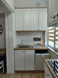 a kitchen with white cabinets and a sink at Katerina's Apartment in Bitola +10 photos