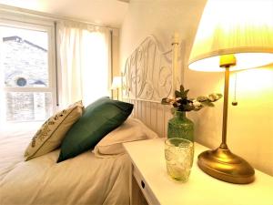 um quarto com uma cama com um candeeiro e uma janela em Noa Apartment En el corazón de los Pirineos em Adrall