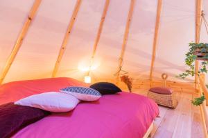 a bed in a tent with pillows on it at Le Scandin'Havre in Hannut
