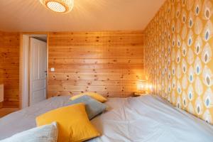Cama en habitación con pared de madera en Le Scandin'Havre, en Hannut