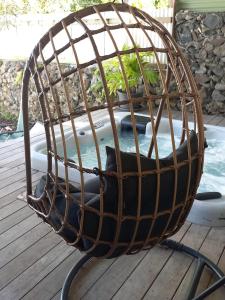 a bird cage sitting on a deck next to a pool at Une pause s'impose au Vauclin avec votre jacuzzi privatif pour 3 nuits minimum in Le Vauclin