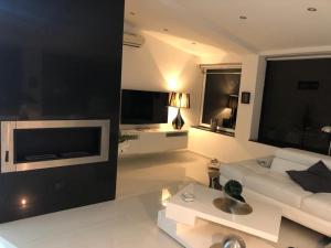 a living room with a white couch and a tv at Villa private Siracusa luxury in Augusta