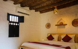 a bedroom with a bed and a window at Sama al Wasil Desert Camp in Shāhiq