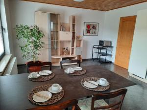 a dining room with a table with plates and chairs at Anne Speicher in Oberzissen