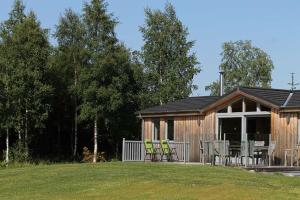 a log cabin with chairs and a table in a yard at Fern Lodge - Luxury Lodge with steamroom in Perthshire in Perth
