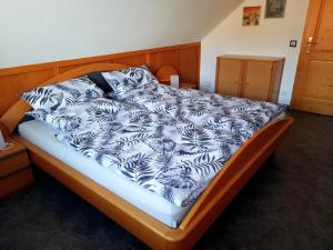 a bed with a black and white comforter at Anne Speicher in Oberzissen