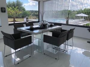 a dining table and chairs in a room with a large window at Villa private Siracusa luxury in Augusta