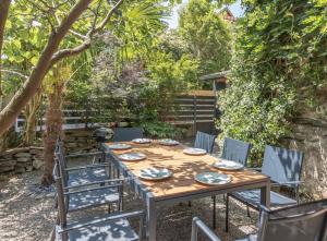 una mesa de madera y sillas en un jardín en gite cosy et moderne au coeur des pyrénées, 