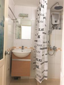 un baño con lavabo y espejo en Wind Chimes Hideaway - Apartment In Central Hanoi, en Hanói 16 fotos más